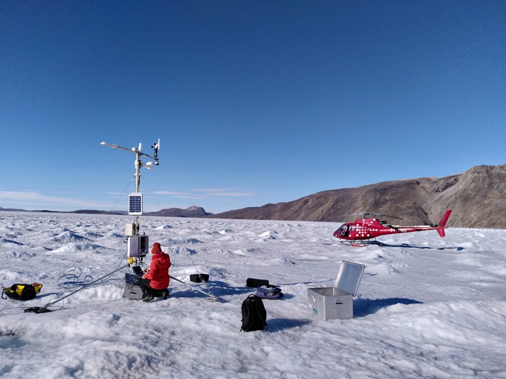 On glacier. Weather station with helicopter in the background.
